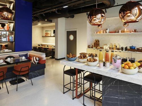 a restaurant with a counter with food on it at Tribe Paris Saint Ouen in Saint-Ouen