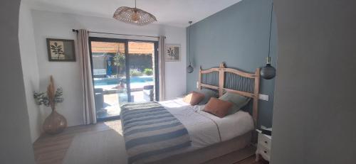 a bedroom with a bed and a sliding glass door at Villa Lailléa in Pont-Péan