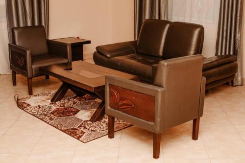 - un salon avec un canapé en cuir et une chaise dans l'établissement Xpine lobster, à Dar es Salaam