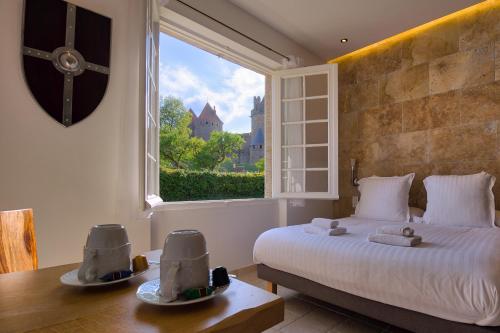 a bedroom with a bed and a large window at GOOD KNIGHT in Carcassonne