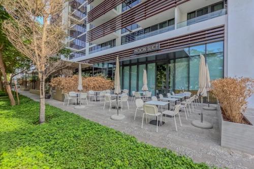 a restaurant with tables and chairs with umbrellas at 1BR Luxury Suite at Misk - Aljada Center - 2WC in Sharjah
