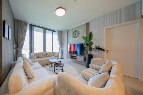 a living room with two couches and a tv at 1BR Luxury Suite at Misk - Aljada Center - 2WC in Sharjah
