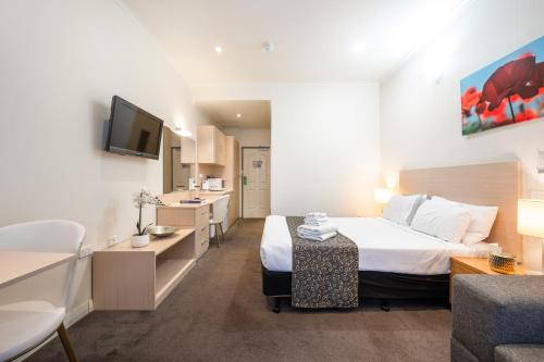 a hotel room with a bed and a bathroom at Adelaide Granada Motor Inn in Adelaide