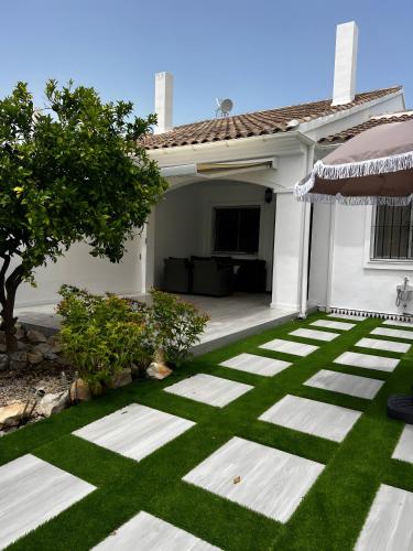 ein weißes Haus mit grünem Rasen in der Unterkunft Adosado La Dolce Vita in Molinell