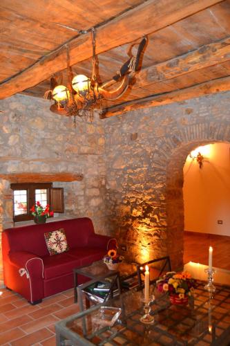 a living room with a red couch and a stone wall at Country Relais La Torretta Baronale in San Giorgio Montagna