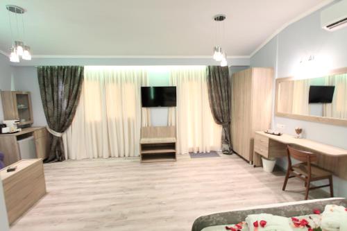 a large living room with a couch and a television at Hotel Mallas in Nea Kalikratia