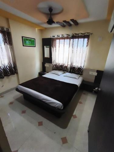 a bedroom with a large bed and windows at Hotel shivalay in Dwarka