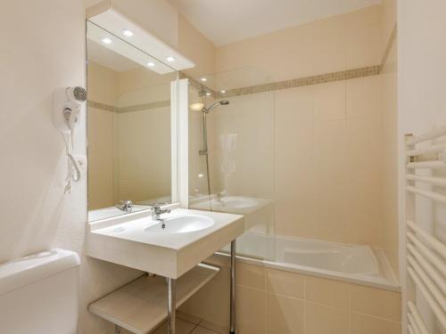 a white bathroom with a sink and a tub at D de Bertheaume N104 2P6 in Plougonvelin
