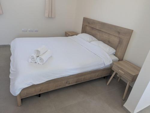 a bed with white sheets and two towels on it at River and Mountains in HaGoshrim