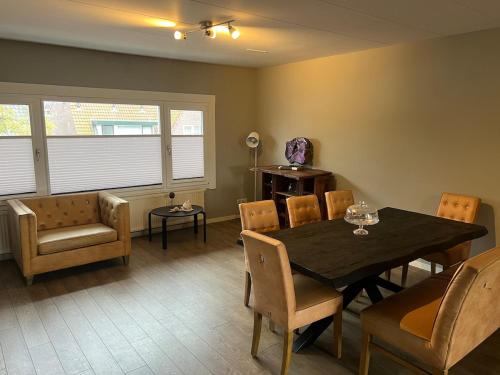 Un comedor con mesa y sillas en Provence Driehuis Apartment, en Driehuis