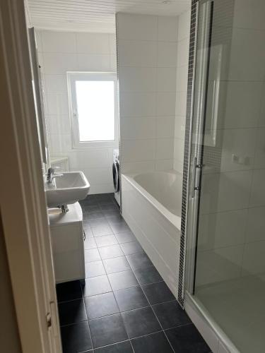 a bathroom with a tub and a sink and a shower at Provence Driehuis Apartment in Driehuis