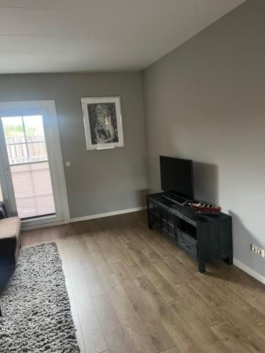 an empty living room with a flat screen tv at Provence Driehuis Apartment in Driehuis