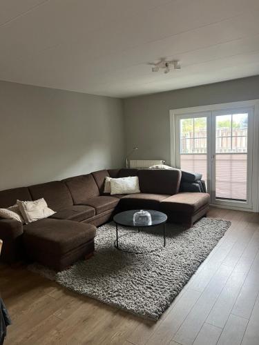 a living room with a brown couch and a table at Provence Driehuis Apartment in Driehuis