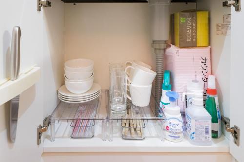 een koelkast gevuld met borden en andere keukengerei bij TDR9分 駄菓子とアートの可愛いミュージアム宿 夢が詰まった小さな宝箱 -TAMU-LAND Urayasu- in Urayasu