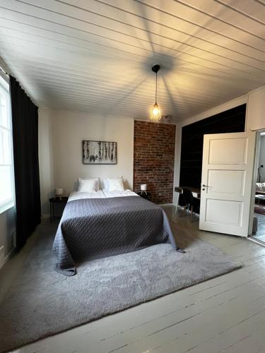 a bedroom with a bed and a brick wall at Unique & premium apartment with free wifi & parking for 2 cars in the center of Kerava in Kerava