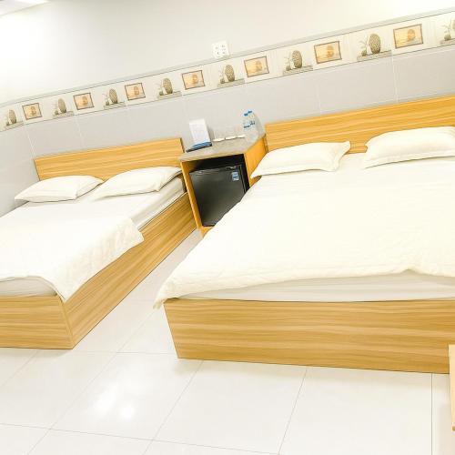 a room with three beds and a desk at Moony Hotel Long Thành in Long Thành