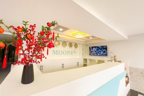 a lobby with a vase of flowers on a counter at Moony Hotel Long Thành in Long Thành
