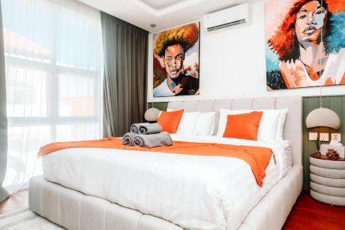 - une chambre avec un grand lit blanc aux accents orange dans l'établissement Casa Medjango Canggu, à Canggu