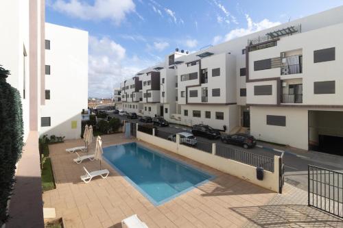 un apartamento con piscina y un edificio en Elegant Apartment with Pool & Moroccan Lounge, en Bouznika