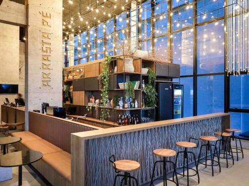 un bar dans un restaurant avec des tabourets dans l'établissement ibis Styles Maceió Pajuçara, à Maceió