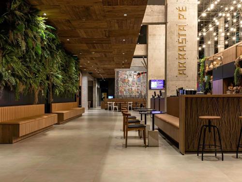 a lobby with chairs and tables in a building at ibis Styles Maceió Pajuçara in Maceió