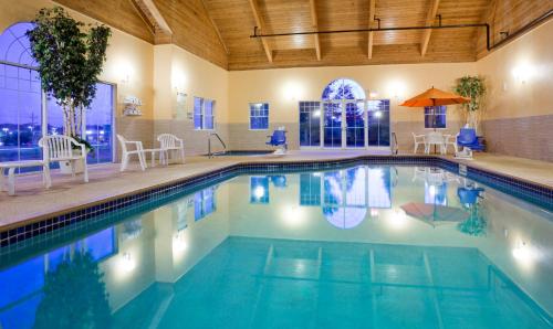 a large swimming pool with blue water in a building at GrandStay Hotel & Suites - Stillwater in Stillwater