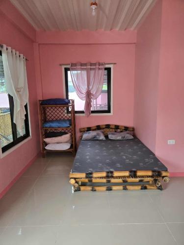 ein Schlafzimmer mit einem Bett in einem rosa Zimmer in der Unterkunft Lola Mamang Resort in General Santos