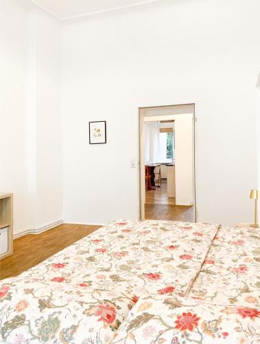 a bedroom with a large bed with a floral bedspread at Sunny Renovated Ground-Floor Apartment in Neukölln in Berlin