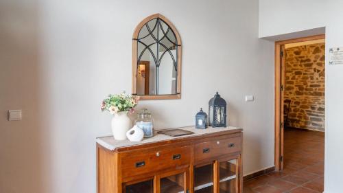 a mirror on top of a wooden dresser in a room at La Fábrica de Juan Antequera - La Joya by Ruralidays in Antequera