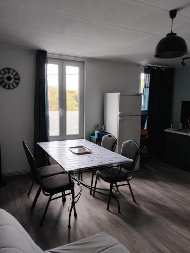 a kitchen with a table and chairs and a refrigerator at Coriandre La Tisanerie 1 room apartment et lits d appoint in Condé-sur-lʼEscaut