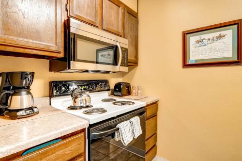 a kitchen with a stove and a microwave at The Forest Neighborhood by Keystone Resort in Keystone