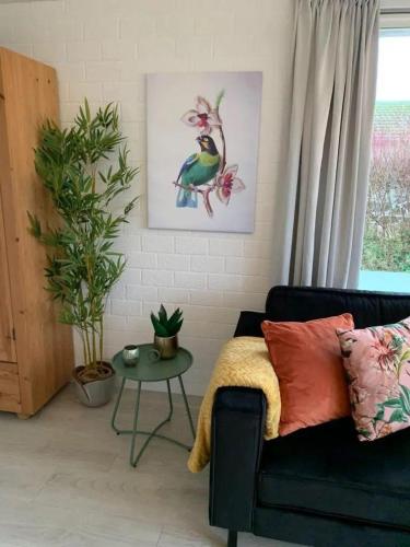 a living room with a couch and a table at Bungalow 001 in Petten