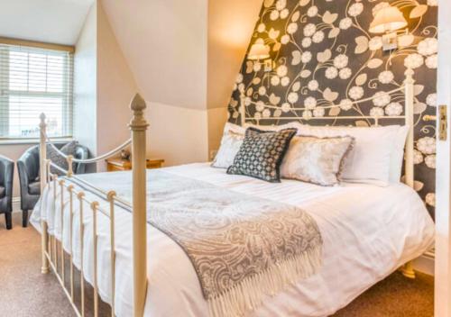 a bedroom with a bed with a large headboard at Rose-Fitt House in Hunstanton