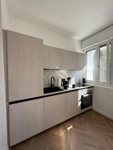 a white kitchen with a sink and a stove at Appartamento Verde in Pordenone