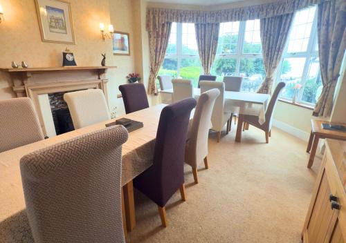 a dining room with a table and chairs and a fireplace at Rose-Fitt House in Hunstanton