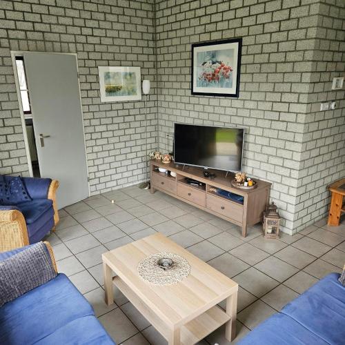a living room with a television and a table at Bungalow 017 in Petten