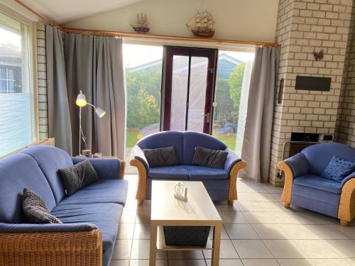 a living room with two blue couches and a table at Bungalow 017 in Petten