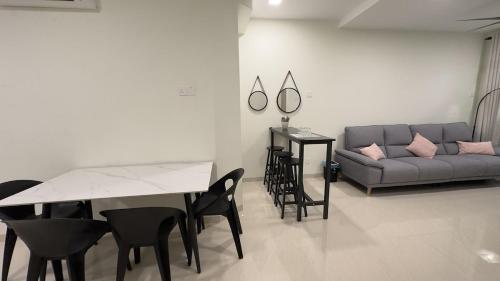 un soggiorno con un divano, un tavolo e delle sedie di Ether 665 Homestay a Sekincan