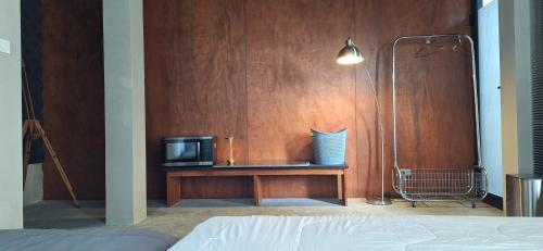 a bedroom with a bed and a tv on a wooden wall at Lanmuanghouse in Ban Pa Kluai