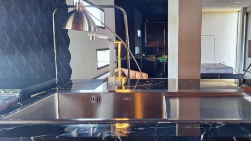 a kitchen counter with a sink and a mirror at Lanmuanghouse in Ban Pa Kluai