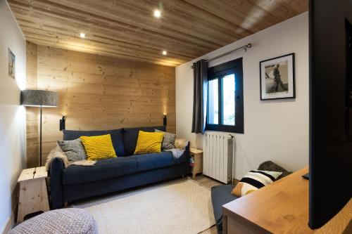 ein Wohnzimmer mit einem blauen Sofa und gelben Kissen in der Unterkunft Chalet Mathilde Les Coches Saturday Changeover in Les Coches