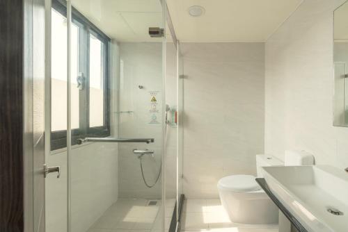 Un baño con ducha, inodoro y lavabo. en 吉村大飯店Fortune Hotel, en Yongkang