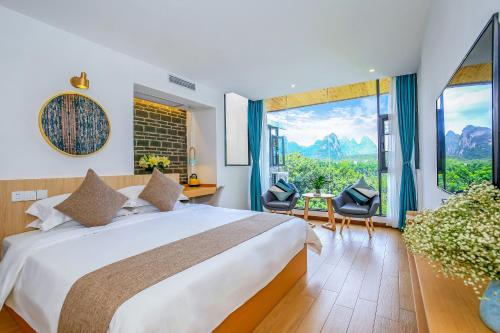 a bedroom with a large bed and a large window at Yangshuo Tea House Inn - By West Street and Li River in Yangshuo