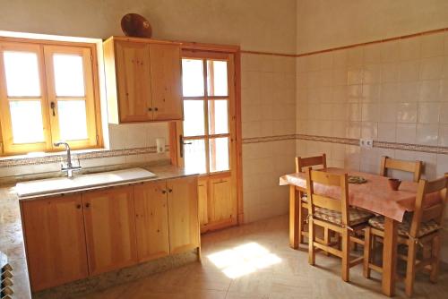 a kitchen with wooden cabinets and a table and a sink at Can Roca in Felanitx