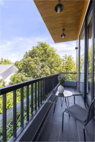 a patio with a table and chairs on a balcony at Charm Champion Villa Hoian in Hoi An