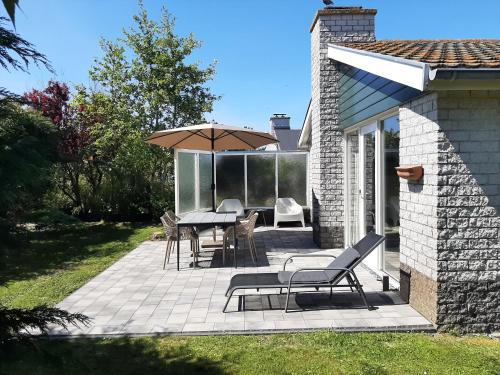 a patio with a table and an umbrella at Bungalow 024 in Petten