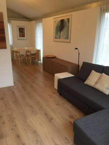 a living room with a couch and a table at Bungalow 027 in Petten