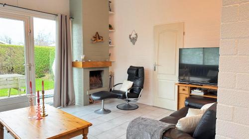 a living room with a couch and a television at Bungalow 028 in Petten