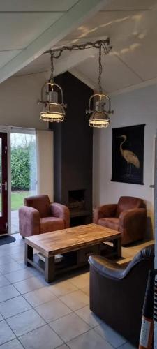 a living room with a wooden table and chairs at Bungalow 038 in Petten