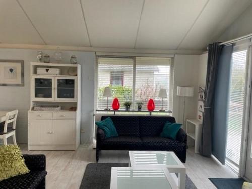 a living room with a couch and a table at Bungalow 040 in Petten